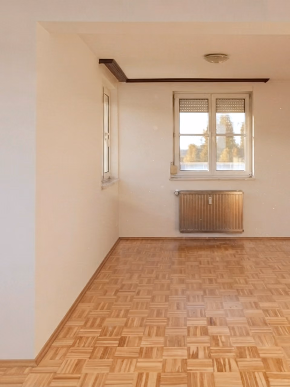 WK8: Zimmer mit Parkettboden, Fenster und Heizkörper