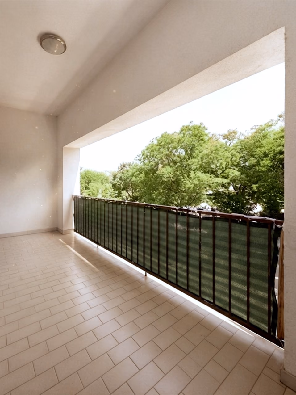 WK8: Überdachter Balkon mit Fliesenboden und Blick ins Grüne